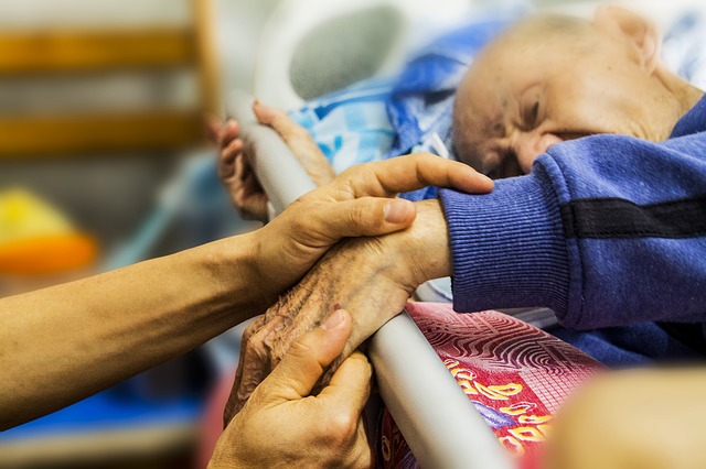Abuelo cama cuidados paliativos hospital manos